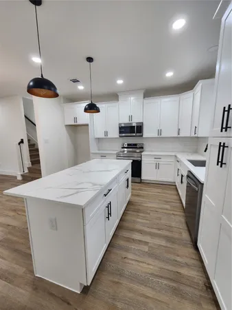 a large kitchen with kitchen island a stove a sink a refrigerator and a center island