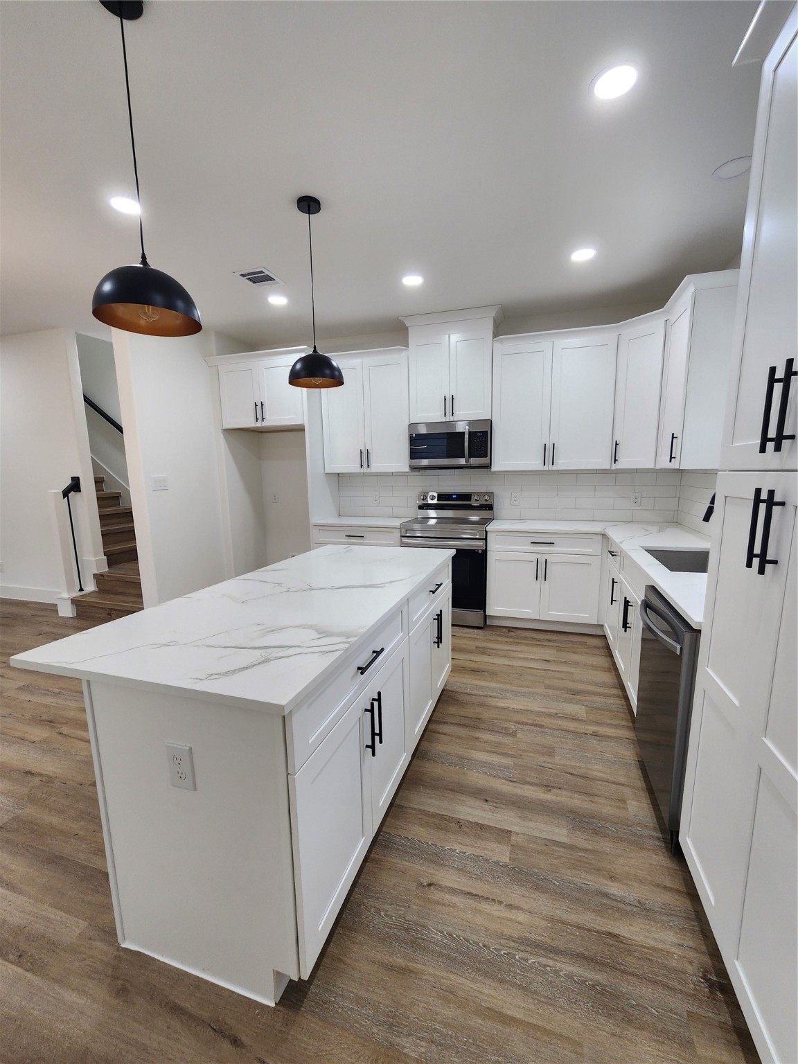 650 Everett Street, Unit B Conroe, TX 77301 - Photo 4 of 20 a large kitchen with kitchen island a stove a sink a refrigerator and a center island