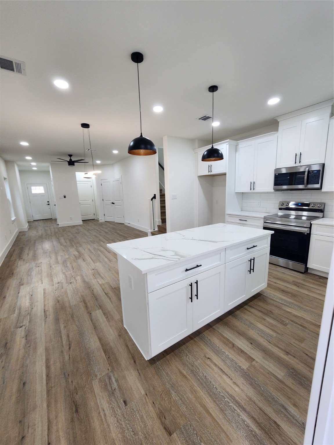 650 Everett Street, Unit B Conroe, TX 77301 - Photo 5 of 20 a large kitchen with stainless steel appliances kitchen island a large island in the center