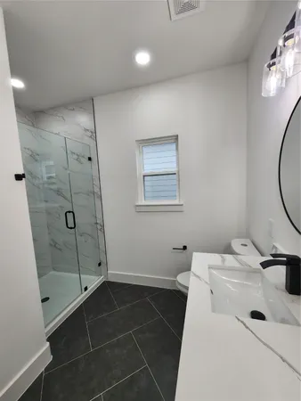 a bathroom with a sink a toilet and shower