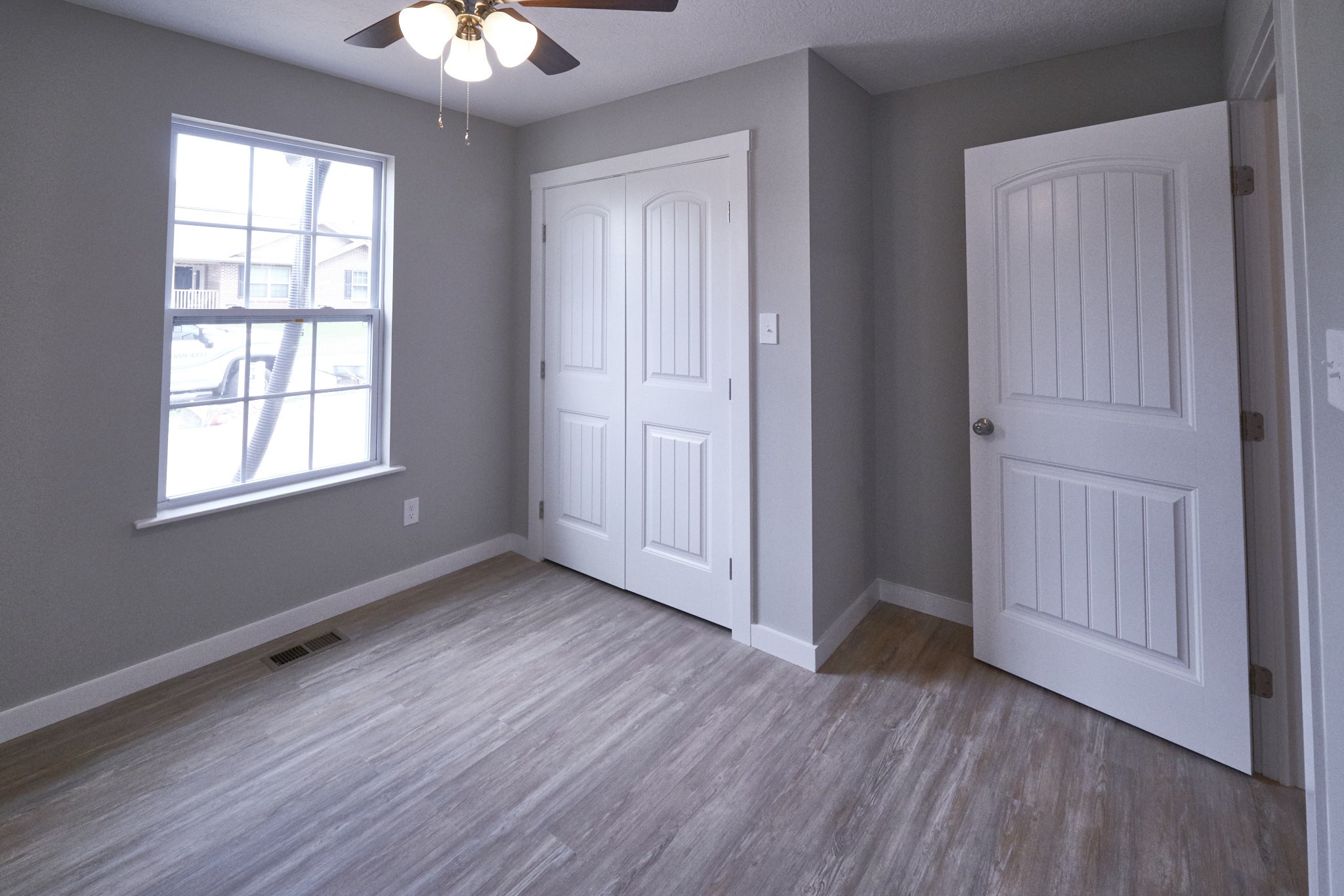 5320 Golden Eagle Lane Corryton, TN 37721 - Photo 14 of 27 an empty room with wooden floor chandelier and windows