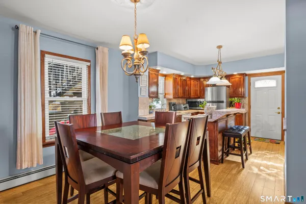 a view of a dining room and livingroom with furniture wooden floor a chandelier
