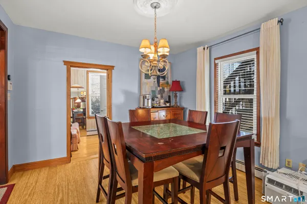 a dining room with furniture window and wooden floor