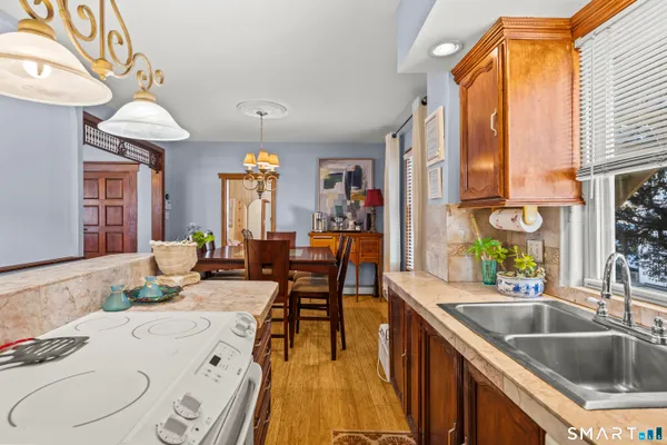 a kitchen with granite countertop a sink a counter space dining table and chairs