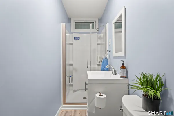 a bathroom with a sink a toilet and shower