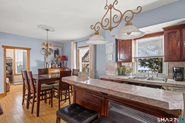 a view of a dining room and livingroom with furniture wooden floor a chandelier