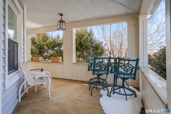 a dining room with wooden floor and a floor to ceiling window