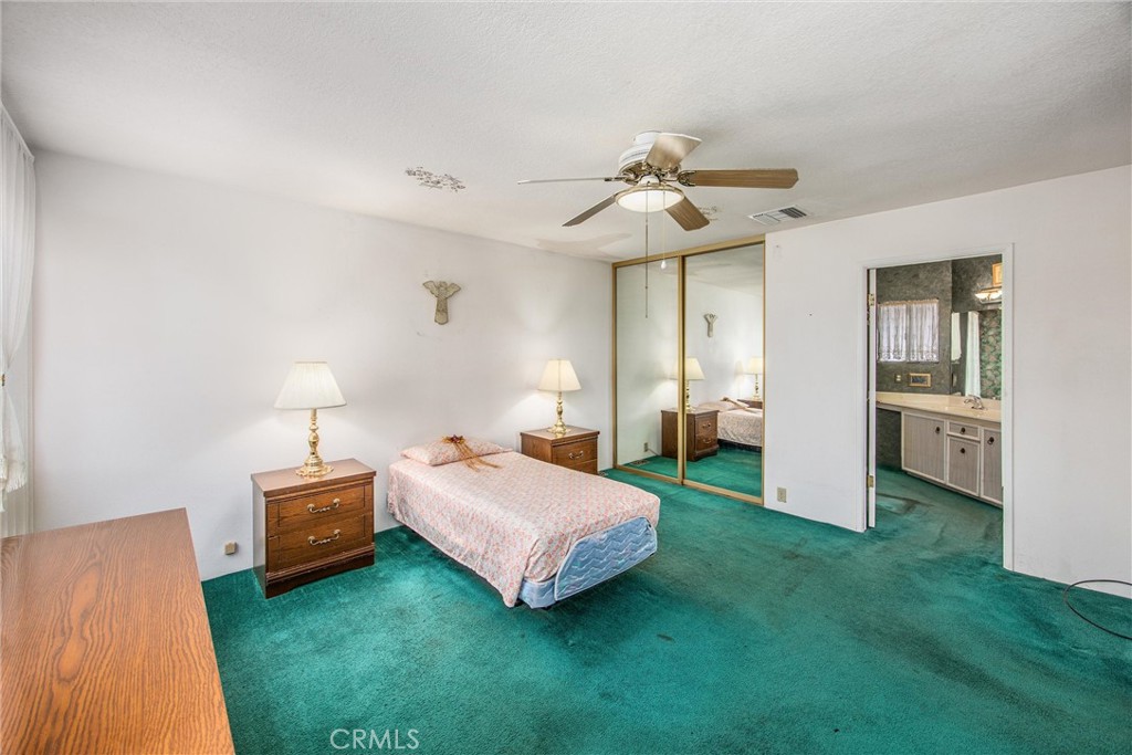 41238 Cheyenne Trail Cherry Valley, CA 92223 - Photo 22 of 44 a bedroom with a bed and a chandelier