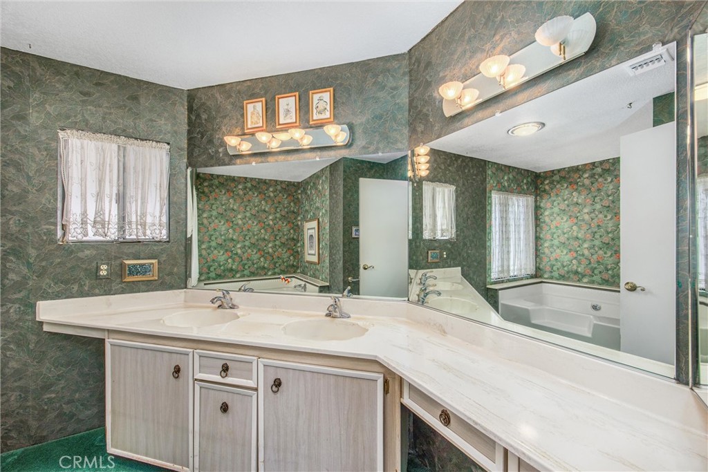 41238 Cheyenne Trail Cherry Valley, CA 92223 - Photo 24 of 44 a bathroom with a sink and a large mirror