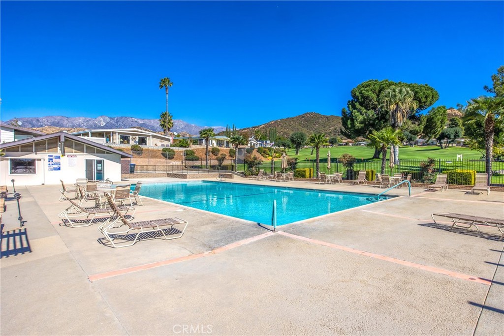 41238 Cheyenne Trail Cherry Valley, CA 92223 - Photo 40 of 44 a view of a swimming pool with a table and chairs under an umbrella