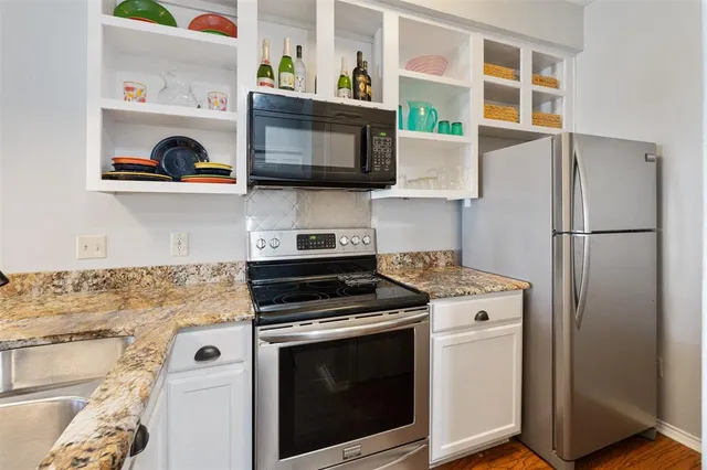 a kitchen with stainless steel appliances granite countertop a stove and a refrigerator