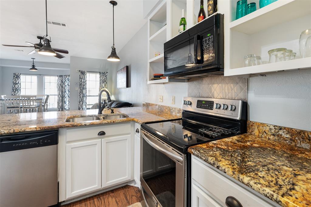 1933 Island Circle, Unit B209 Tool, TX 75143 - Photo 14 of 30 a kitchen with stainless steel appliances granite countertop a sink a stove a microwave and wooden cabinets