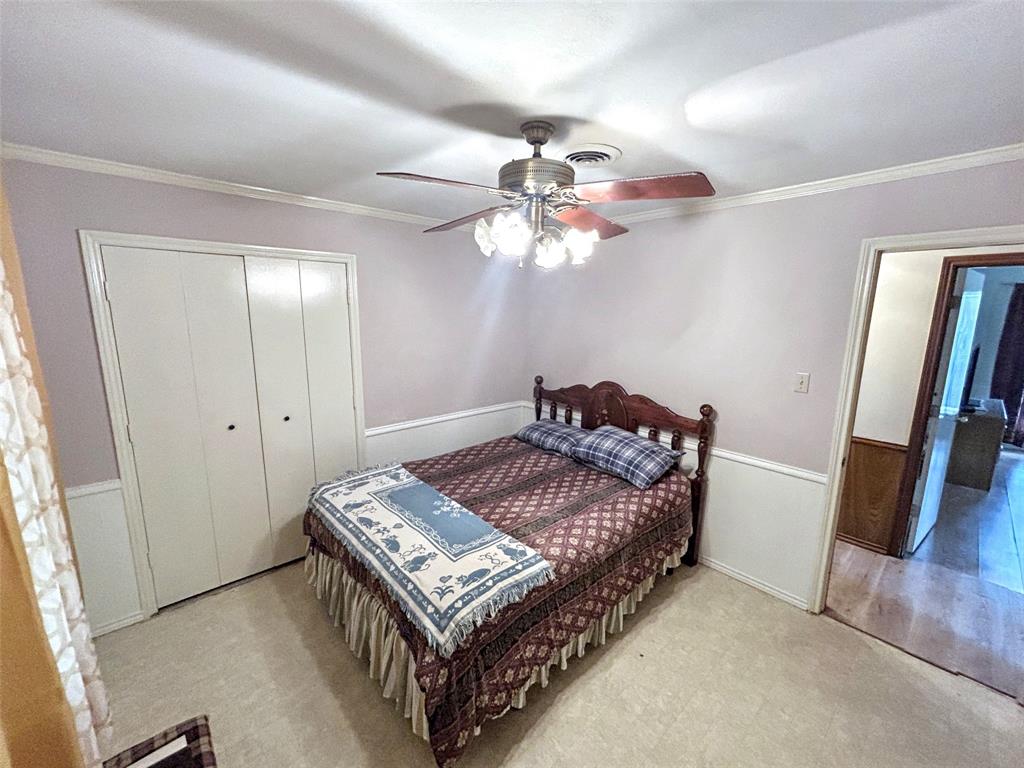4905 Rippy Road Flower Mound, TX 75028 - Photo 17 of 29 Bedroom featuring ornamental molding, wainscoting, a closet, a ceiling fan, and carpet flooring