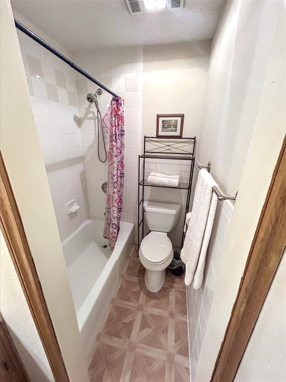 4905 Rippy Road Flower Mound, TX 75028 - Photo 18 of 29 Bathroom with toilet and shower / tub combo with curtain