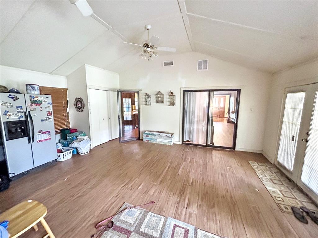 4905 Rippy Road Flower Mound, TX 75028 - Photo 23 of 29 Unfurnished living room featuring vaulted ceiling, wood finished floors, plenty of natural light, and a ceiling fan