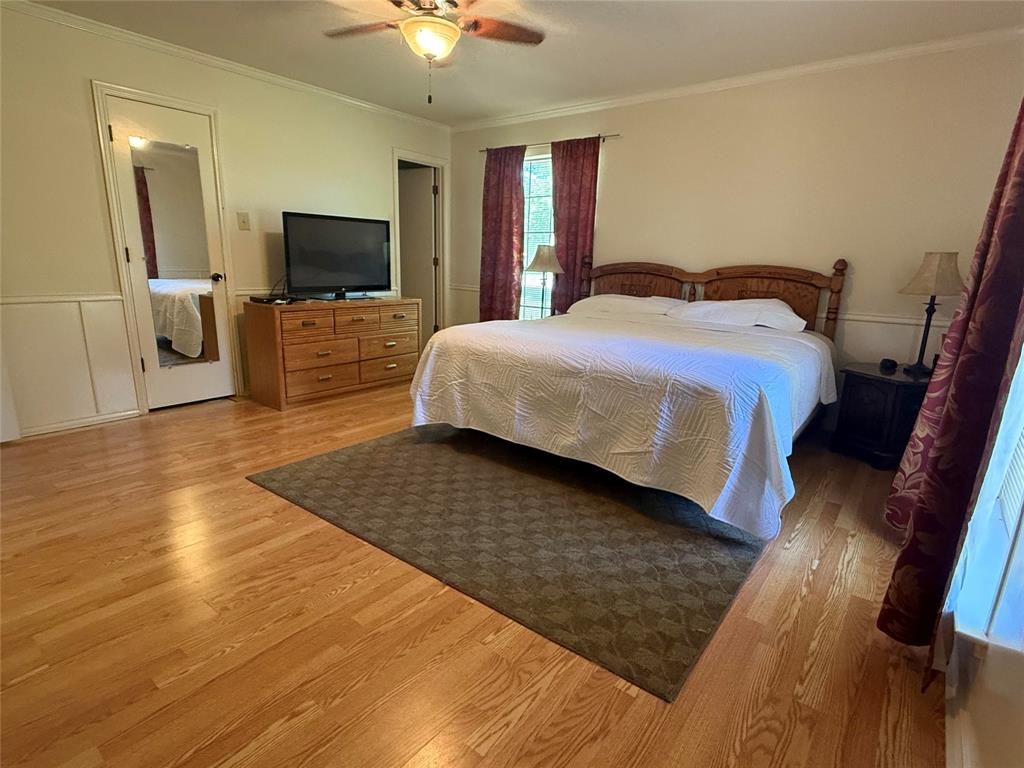 4905 Rippy Road Flower Mound, TX 75028 - Photo 26 of 29 Bedroom with light wood-style flooring, ornamental molding, and ceiling fan