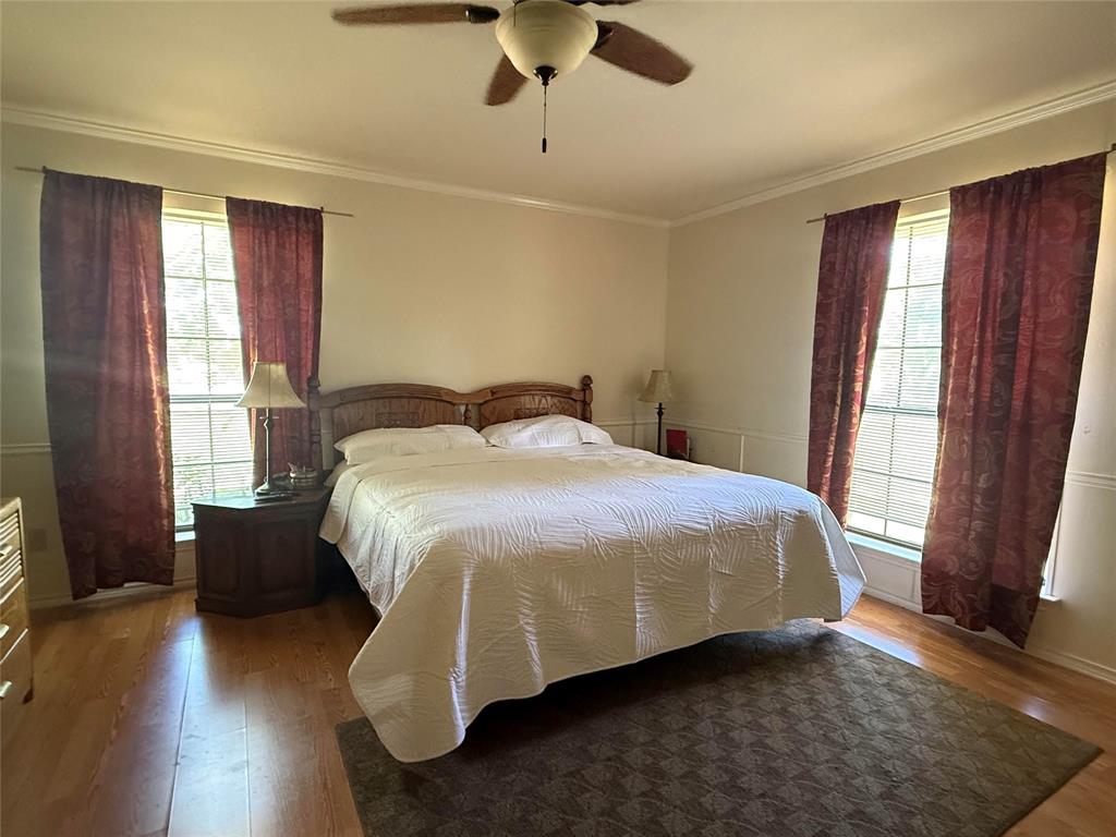 4905 Rippy Road Flower Mound, TX 75028 - Photo 28 of 29 Bedroom featuring wood finished floors, multiple windows, crown molding, and ceiling fan