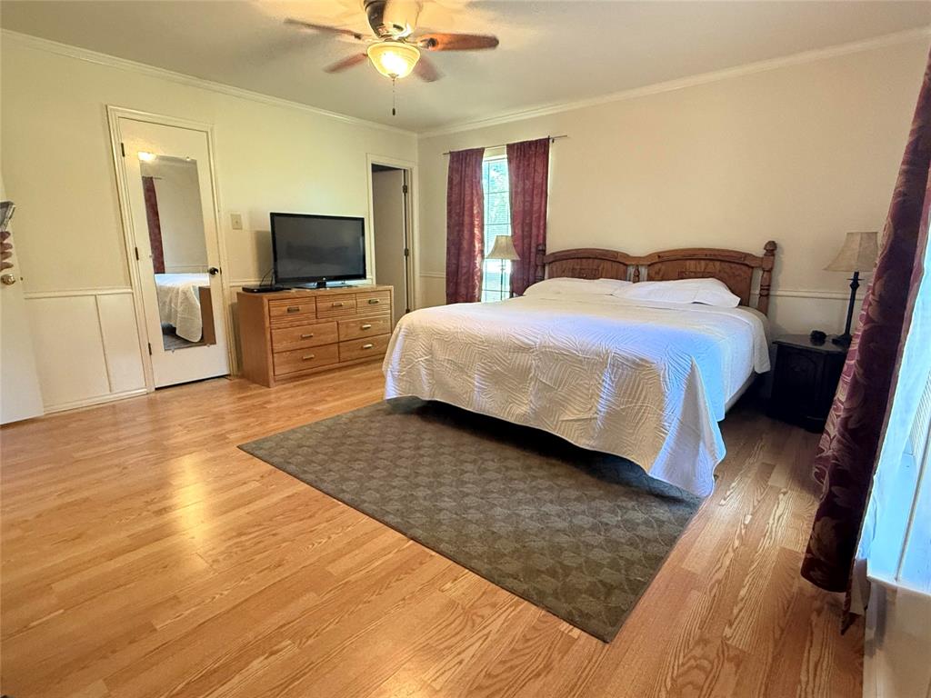 4905 Rippy Road Flower Mound, TX 75028 - Photo 29 of 29 Bedroom with light wood-type flooring, crown molding, and a ceiling fan
