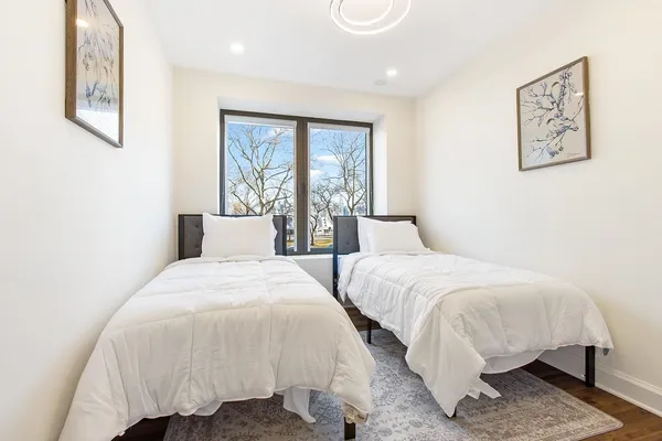 a bedroom with two beds and painting on the wall