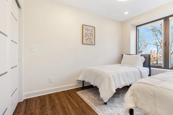 a bedroom with two beds and a painting on the wall
