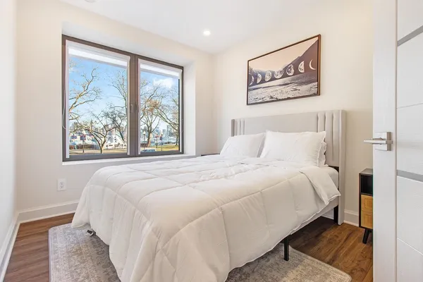 a bedroom with a bed and a painting on the wall