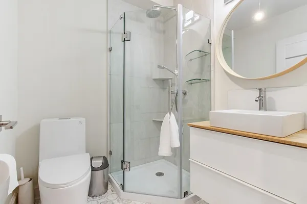 a bathroom with a sink a toilet and shower
