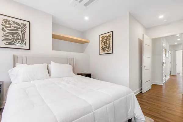 a bedroom with a bed and wooden floor