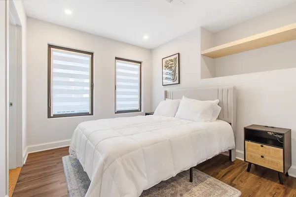 a bedroom with a bed and wooden floor