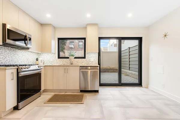 a kitchen with stainless steel appliances granite countertop a stove a sink and a microwave