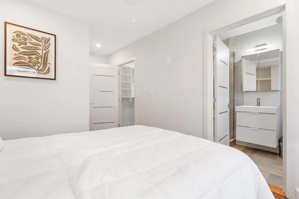a bedroom with a bed and a painting on the wall