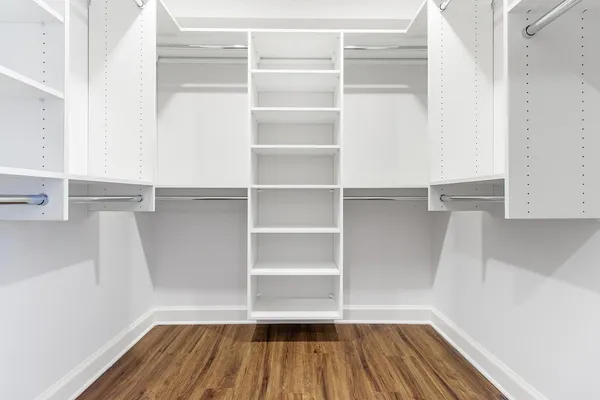 a view of walk in closet with empty racks