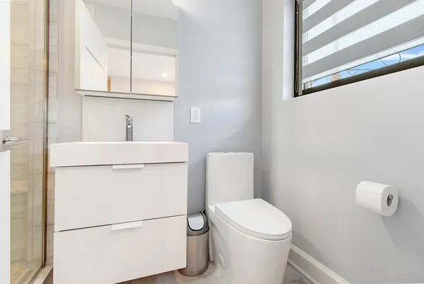 a white toilet sitting next to a bathroom sink