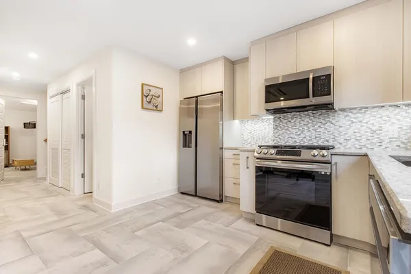 a kitchen with stainless steel appliances granite countertop a stove a microwave and a refrigerator