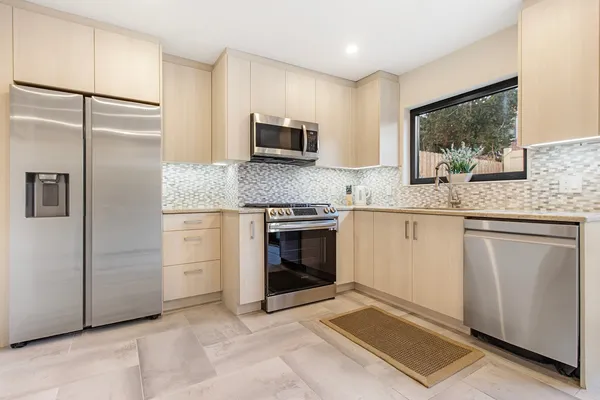a kitchen with granite countertop a sink stainless steel appliances and counter space