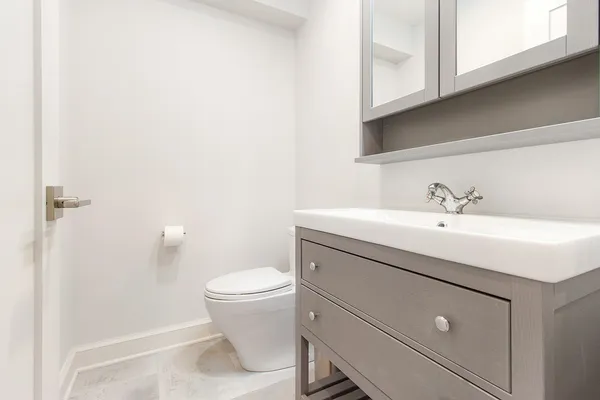 a bathroom with a sink a toilet and a mirror