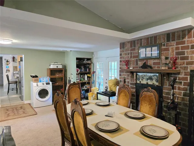 a dining room with furniture a rug and white walls