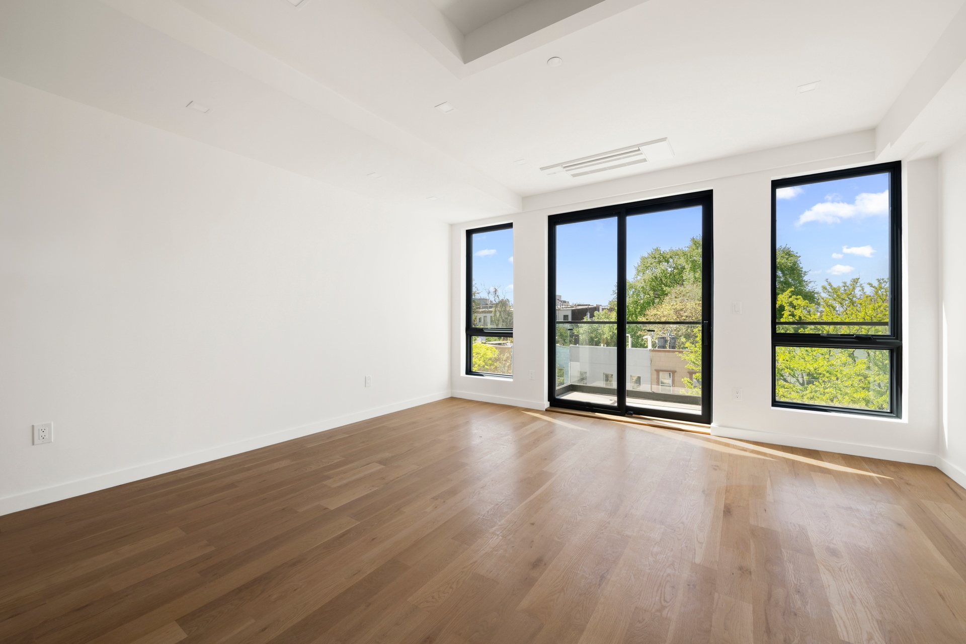78 Harman Street, Unit 4F Brooklyn, NY 11221 - Photo 2 of 9 an empty room with wooden floor and windows