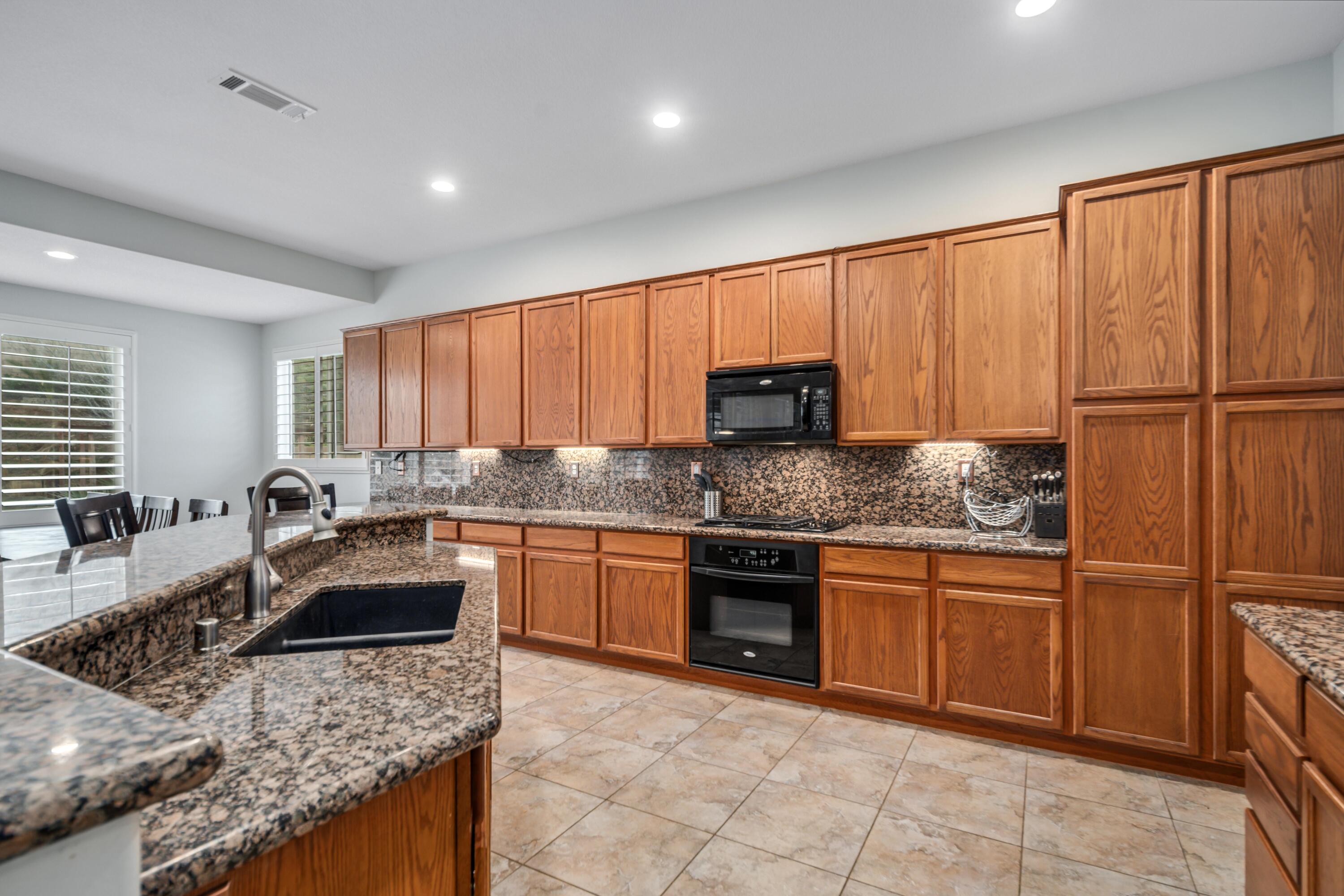 40467 Tiger Way Palmdale, CA 93551 - Photo 13 of 60 a kitchen with stainless steel appliances granite countertop a sink stove refrigerator and cabinets