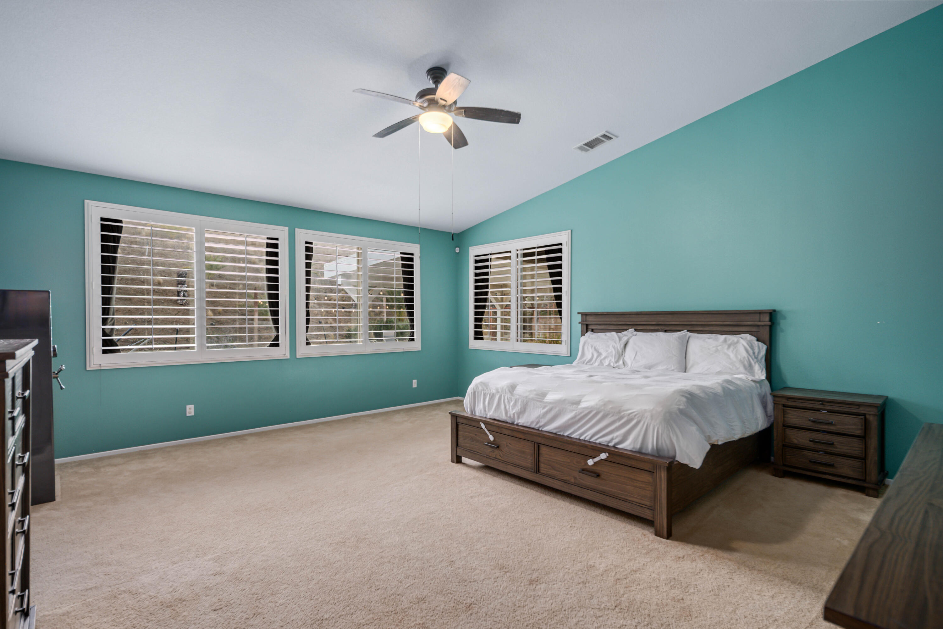 40467 Tiger Way Palmdale, CA 93551 - Photo 21 of 60 a spacious bedroom with a bed and a chandelier