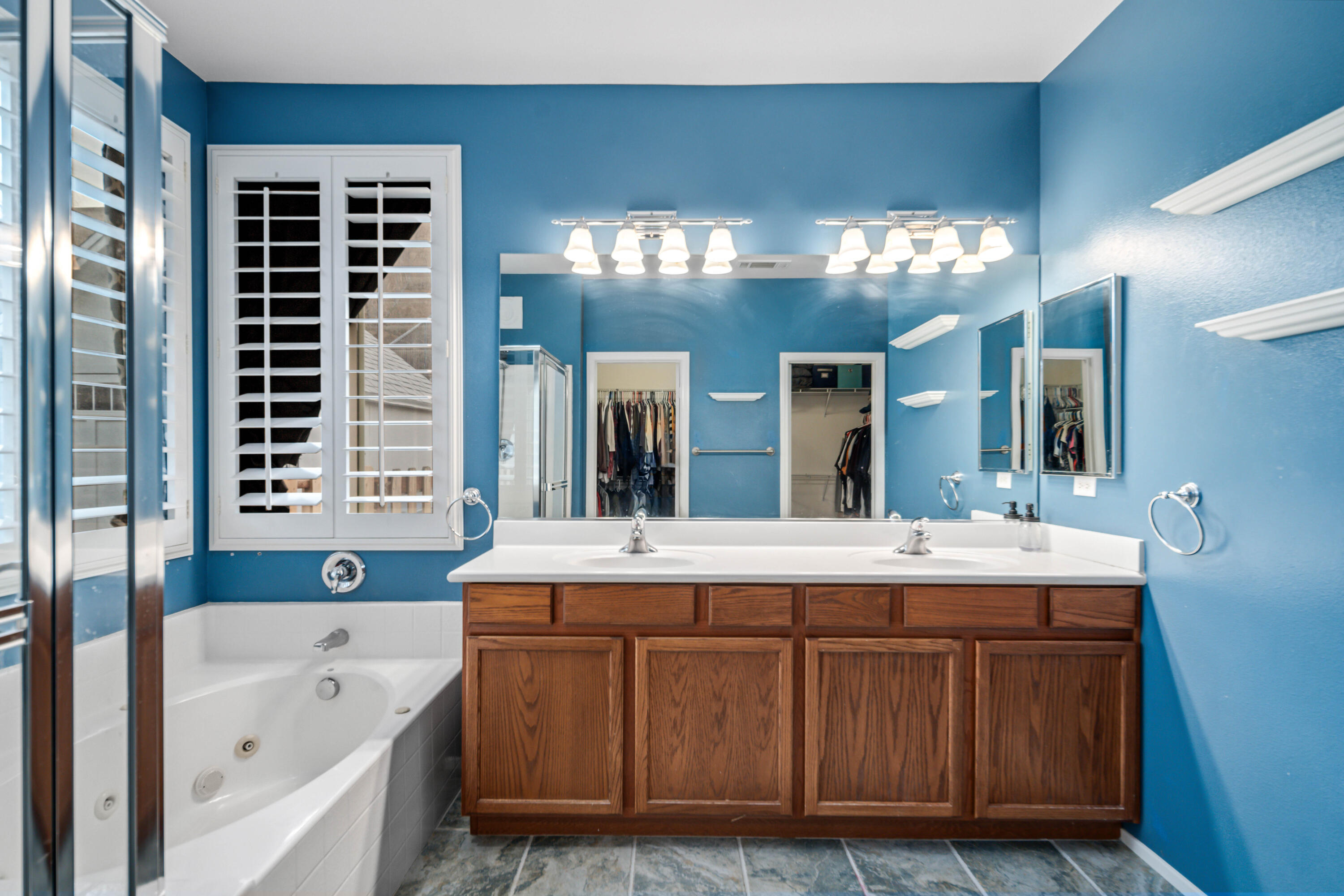 40467 Tiger Way Palmdale, CA 93551 - Photo 25 of 60 a bathroom with a bathtub a double vanity sink and a large mirror