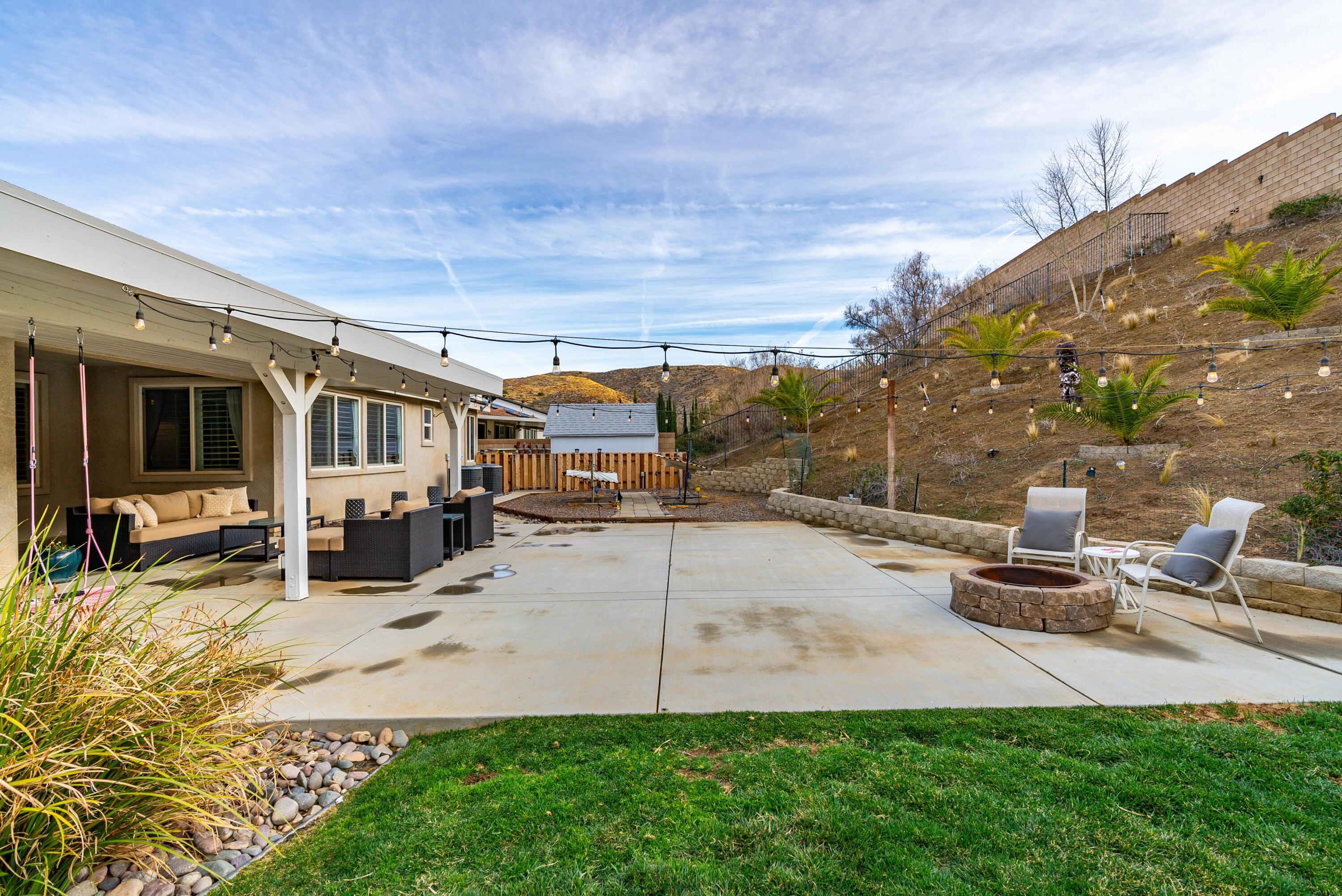 40467 Tiger Way Palmdale, CA 93551 - Photo 45 of 60 a view of a patio with couches and table and chairs with wooden fence