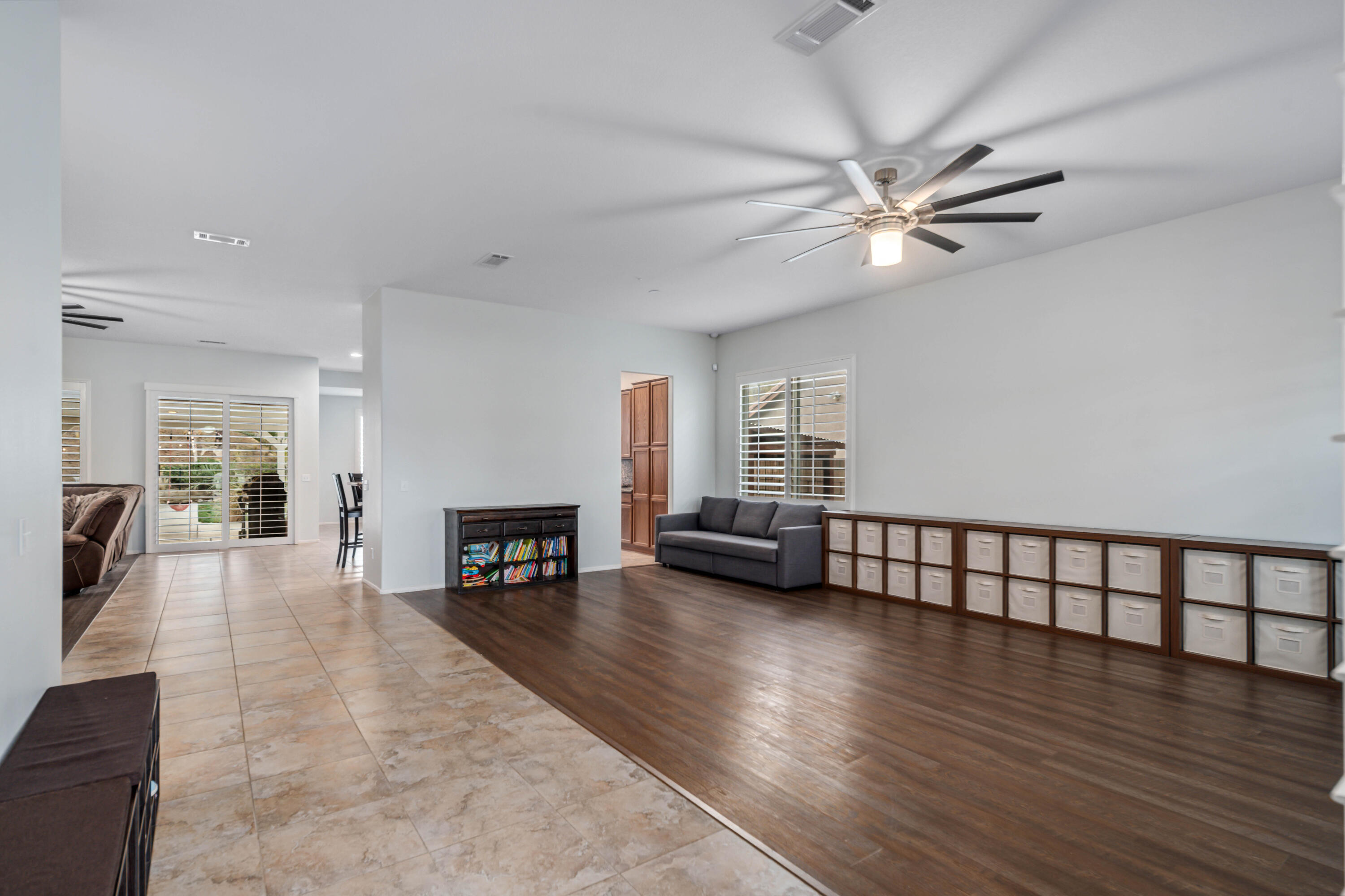 40467 Tiger Way Palmdale, CA 93551 - Photo 8 of 60 an empty room with fireplace chandelier fan and windows