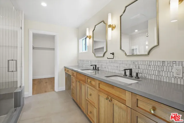 a bathroom with a double vanity sink mirror and shower