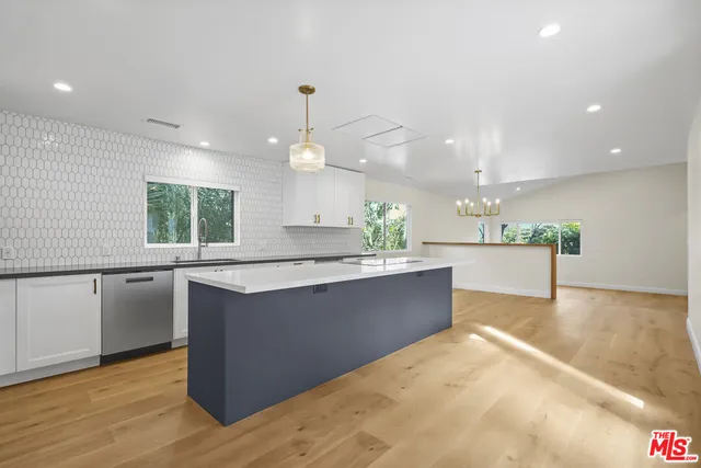 a large kitchen with kitchen island a sink stainless steel appliances and a counter top
