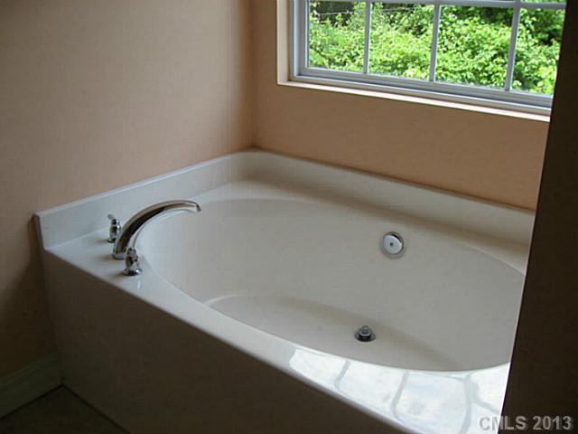 5727 Charing Place Charlotte, NC 28211 - Photo 11 of 15 a bath tub sitting in a bathroom next to a window