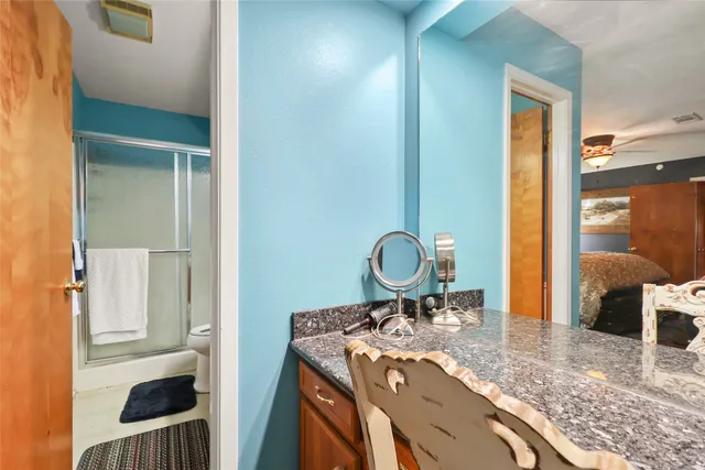 a bathroom with a granite countertop sink toilet and shower