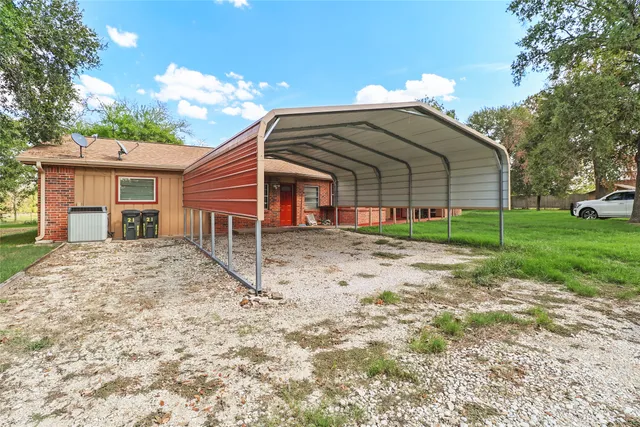 a view of a wooden house with a small yard and wooden fence