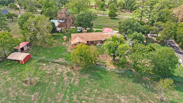 an aerial view of a house with a yard and lake view