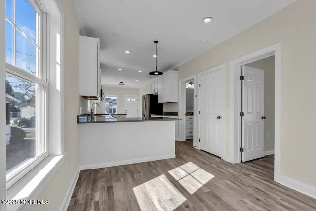 a view of a kitchen with wooden floor and a window