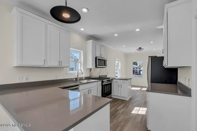 a kitchen with stainless steel appliances granite countertop a sink a stove top oven a counter space and cabinets